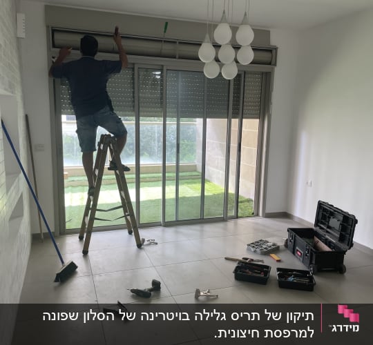 אדם מתקין תריסים על חלון גדול עם סולם